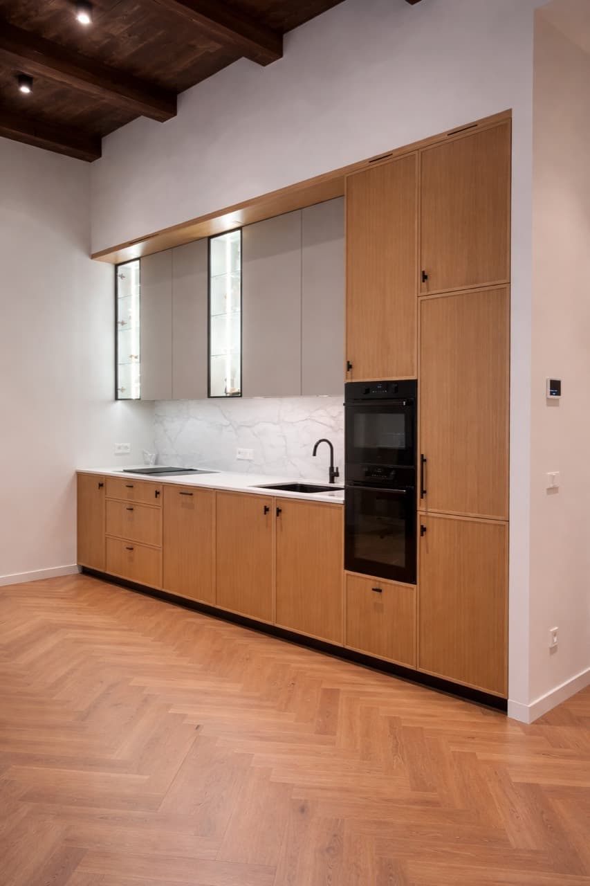 Светлая линейная кухня Baron с мягким деревянным тоном как часть подборки предметов и акцентов.