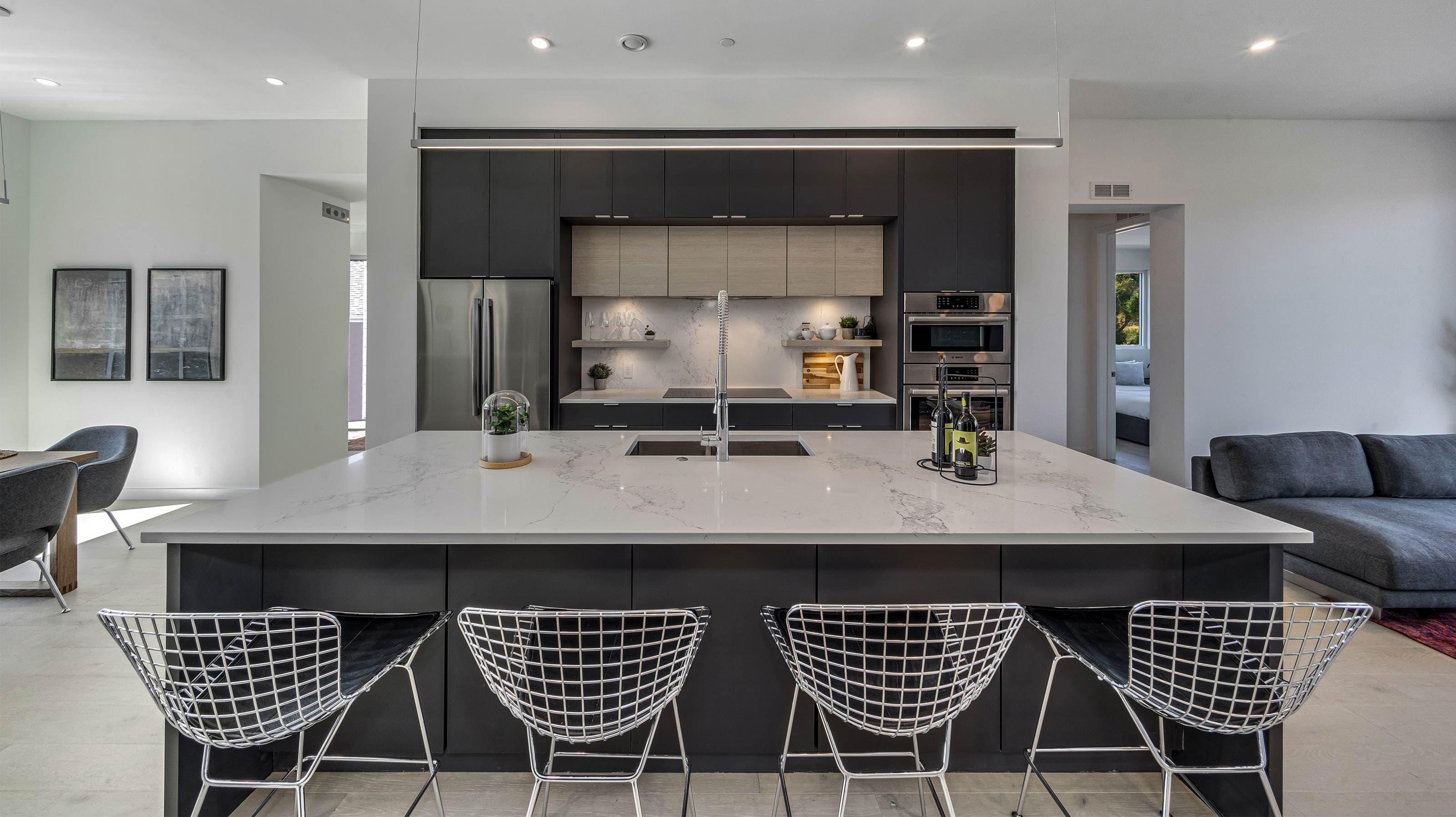 Темная кухня Baron с островом в открытом жилом пространстве и насыщенной архитектурной атмосферой.